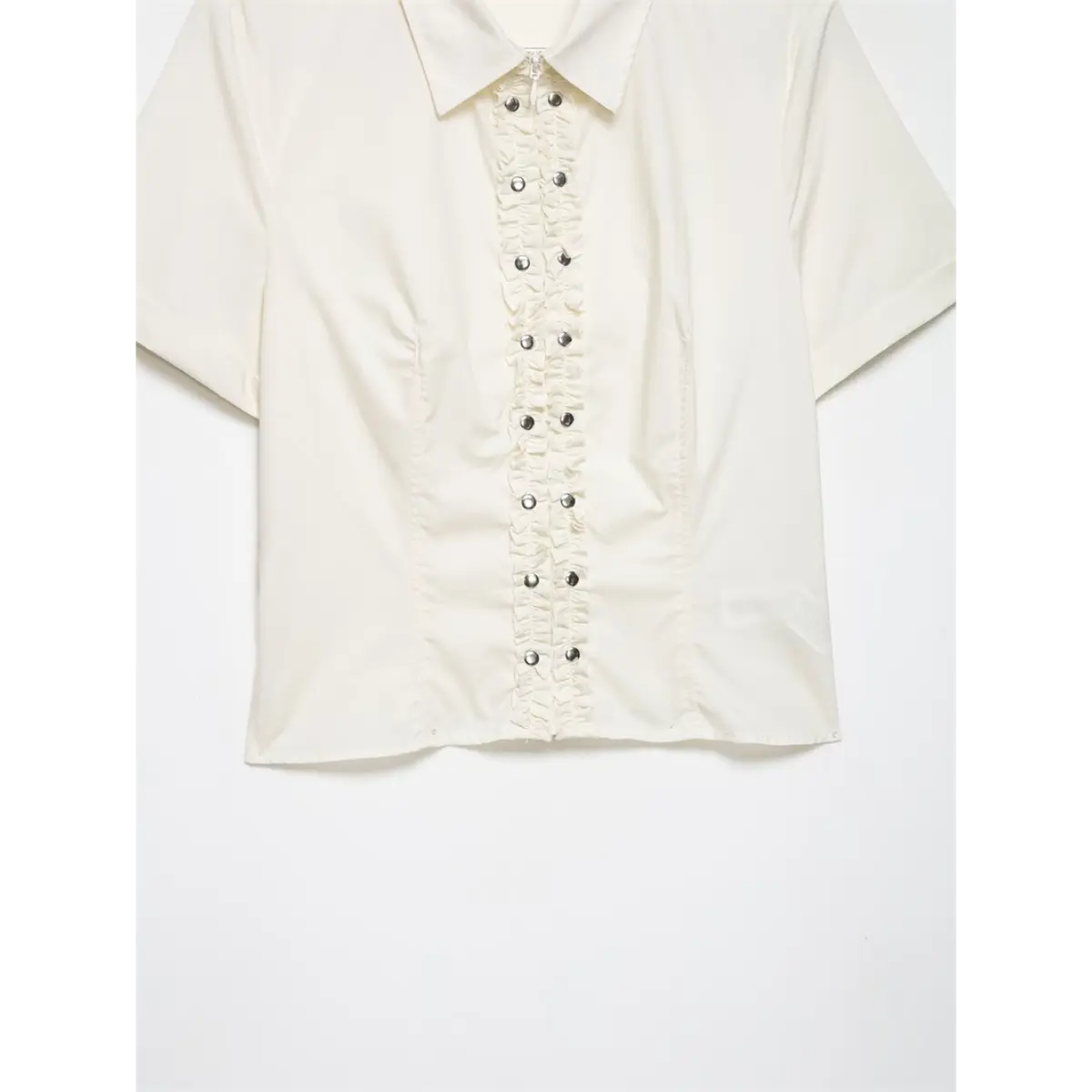 Full front shot of cream shirt with ruffled placket, metal buttons, and pointed collar