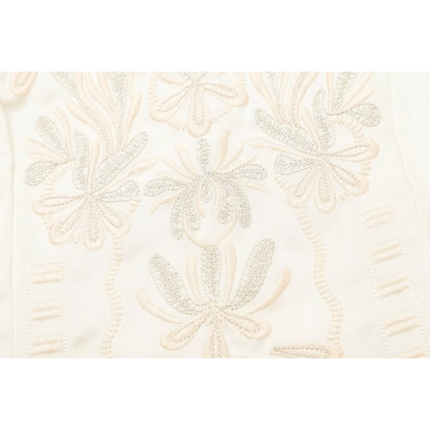 Macro detail of floral stitch patterns on cream satin embroidered camisole