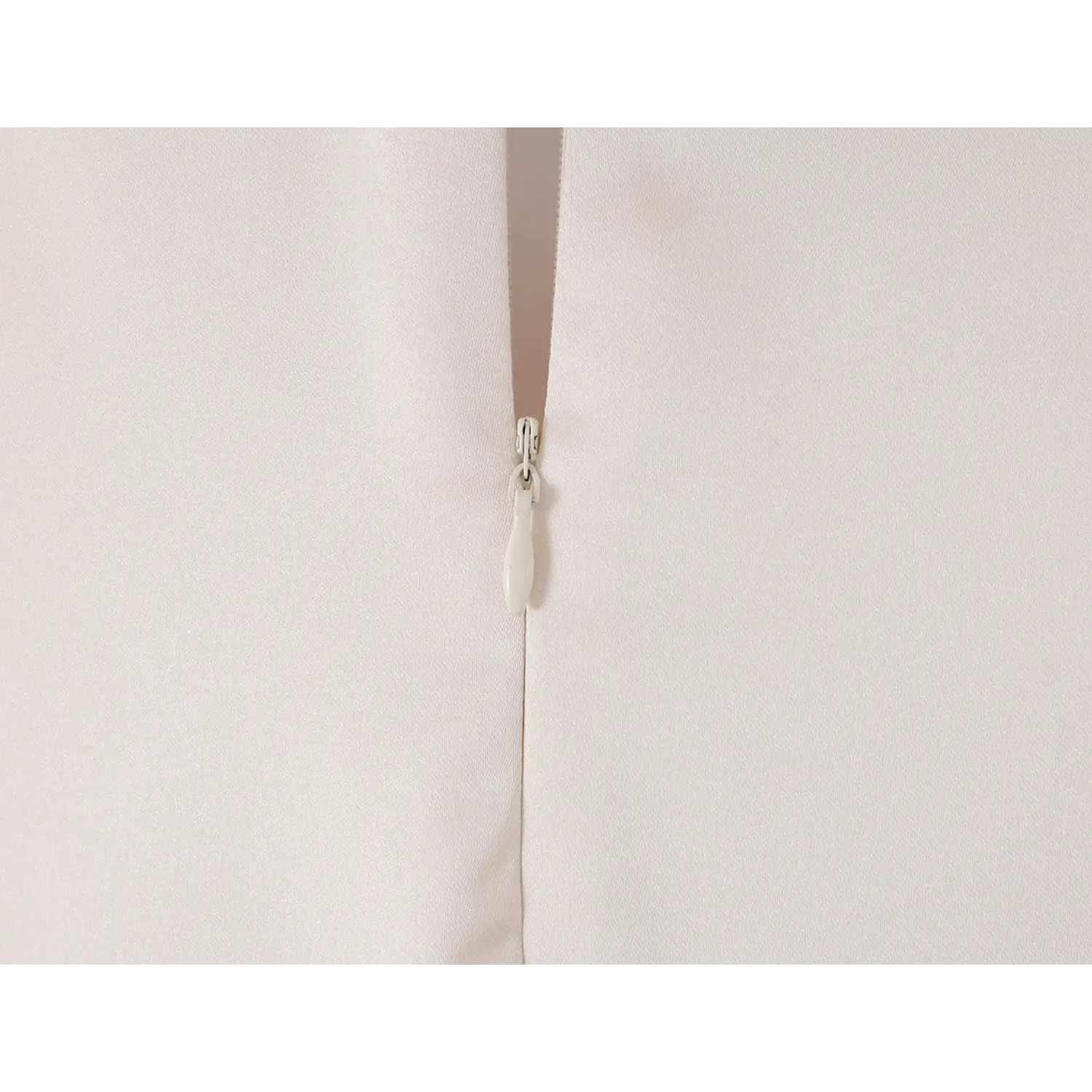 Cream satin dress center back invisible zipper macro close-up, matching teardrop zipper pull, neat fine serging stitching, smooth hidden zipper easy wear inner craft detail shot