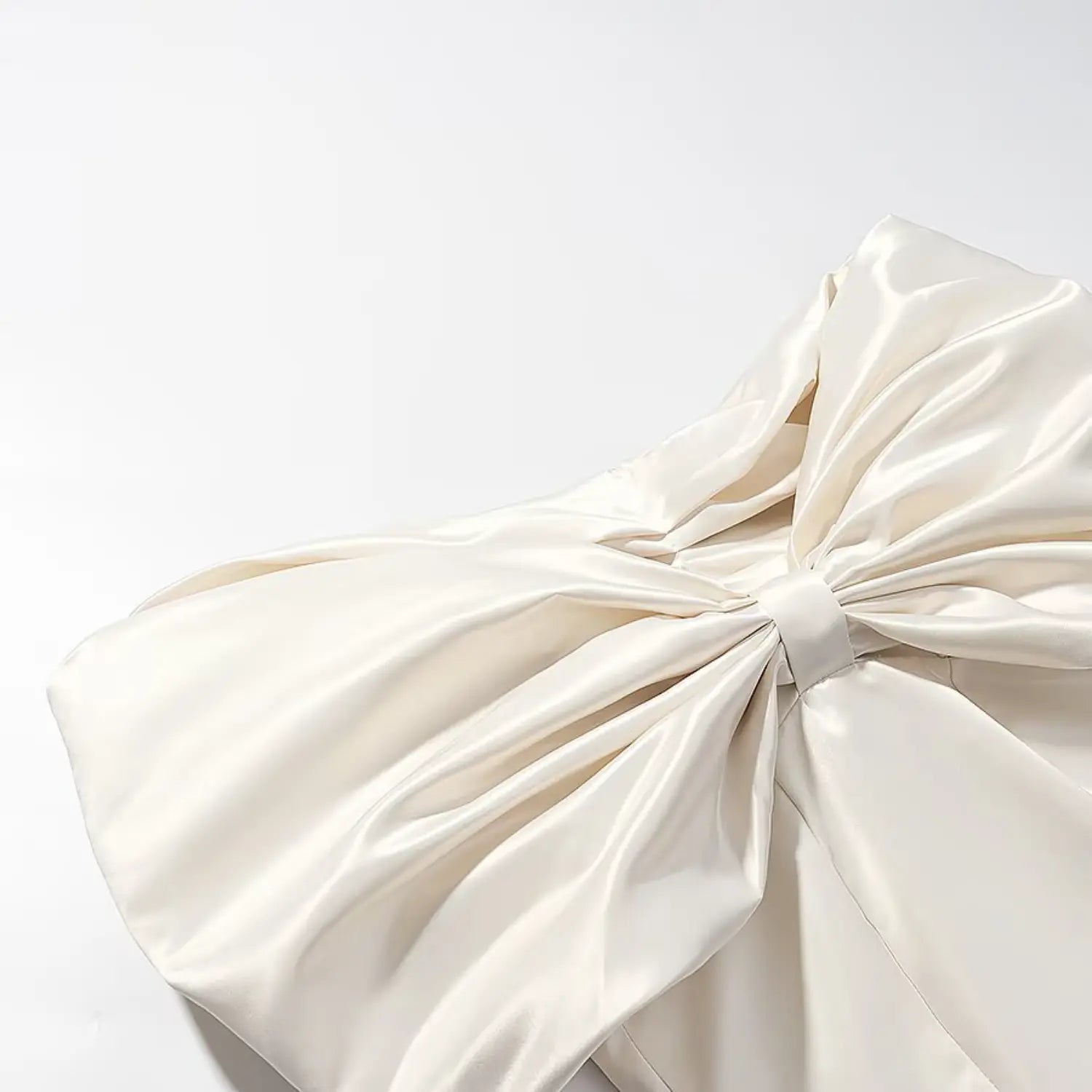 Full oversized satin bow close-up, cream glossy satin fabric