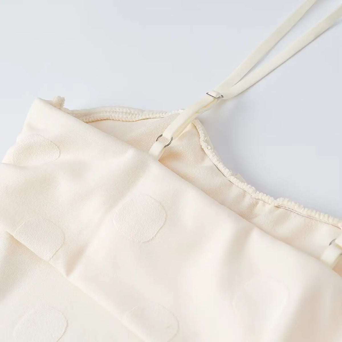 Close-up of strap adjuster and neckline trim