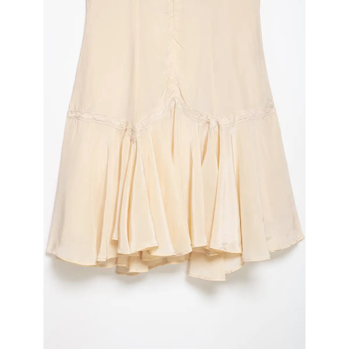 Close-up of the dress's back skirt hem, showing the lace trim and flared satin panels.