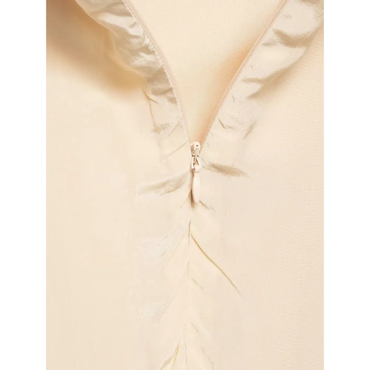 Close-up of the dress's center back zipper, with a satin pull tab and ruched seam.