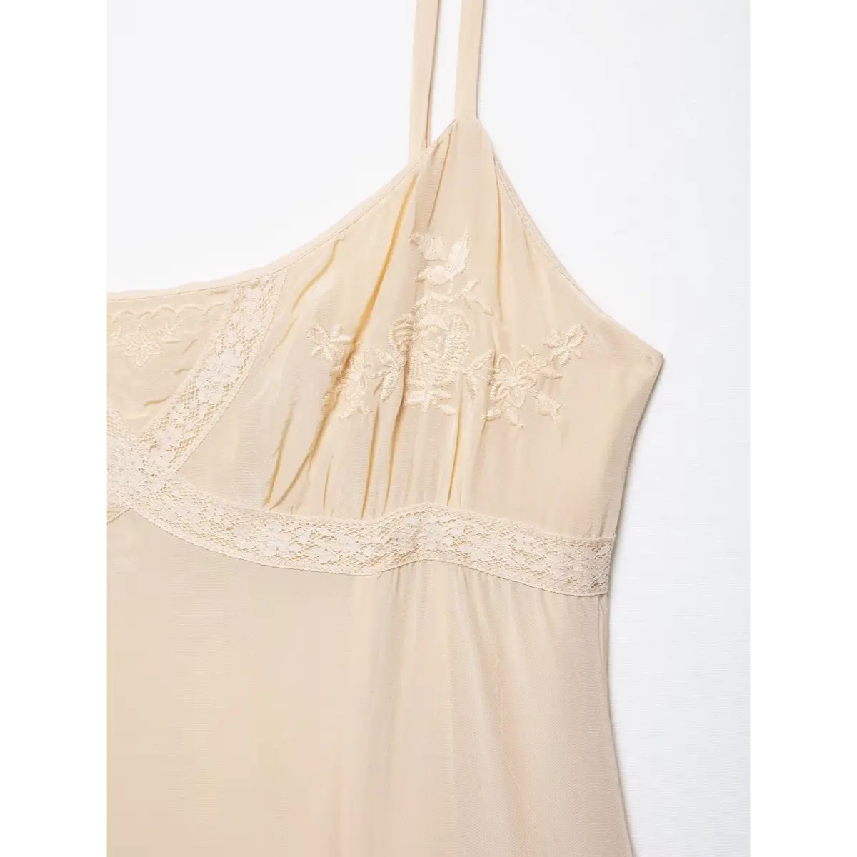 Close-up of the dress's floral embroidery on the bust, paired with crisscross lace trim.