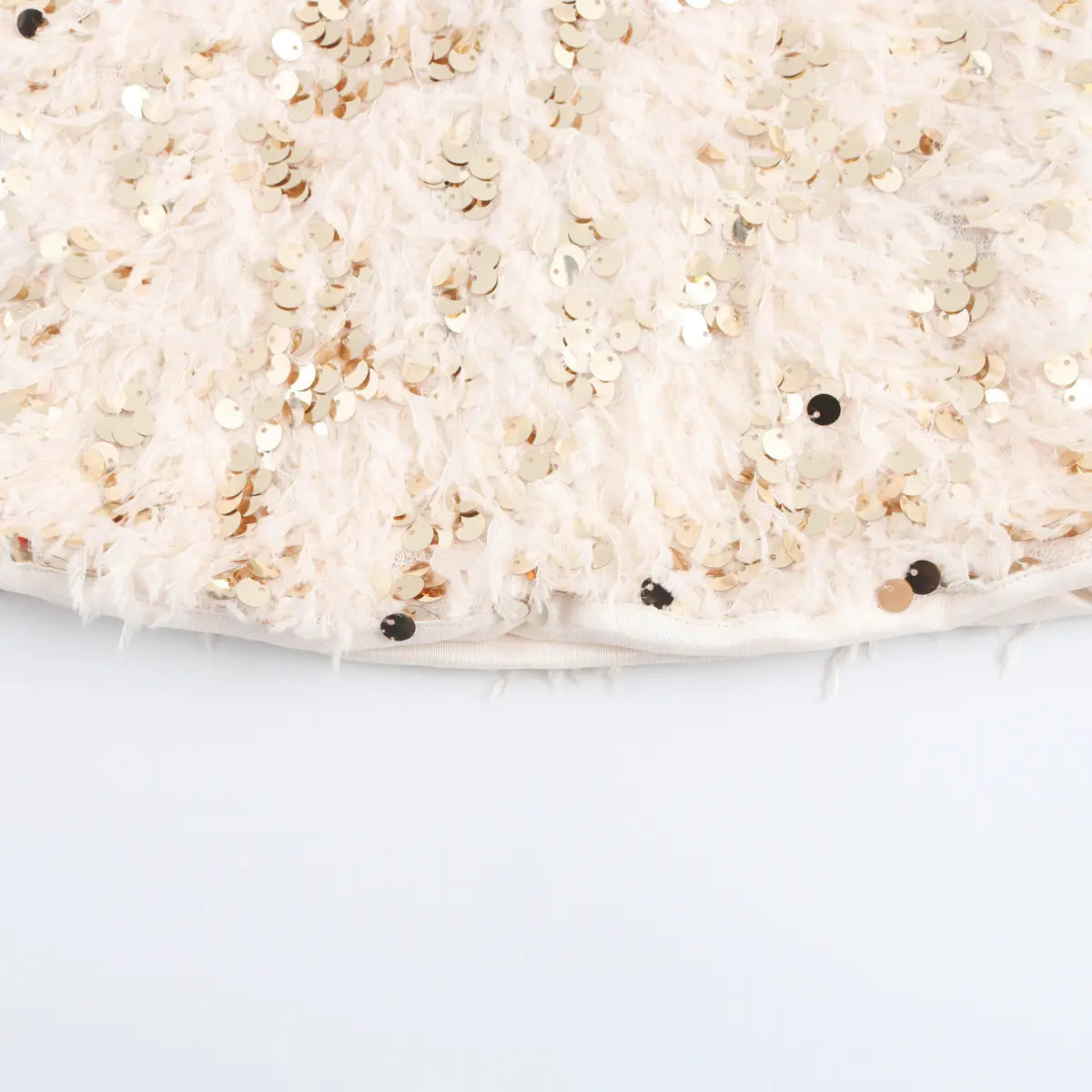 Close-up detail of the cream feather and sequin fabric texture on the bandeau top.
