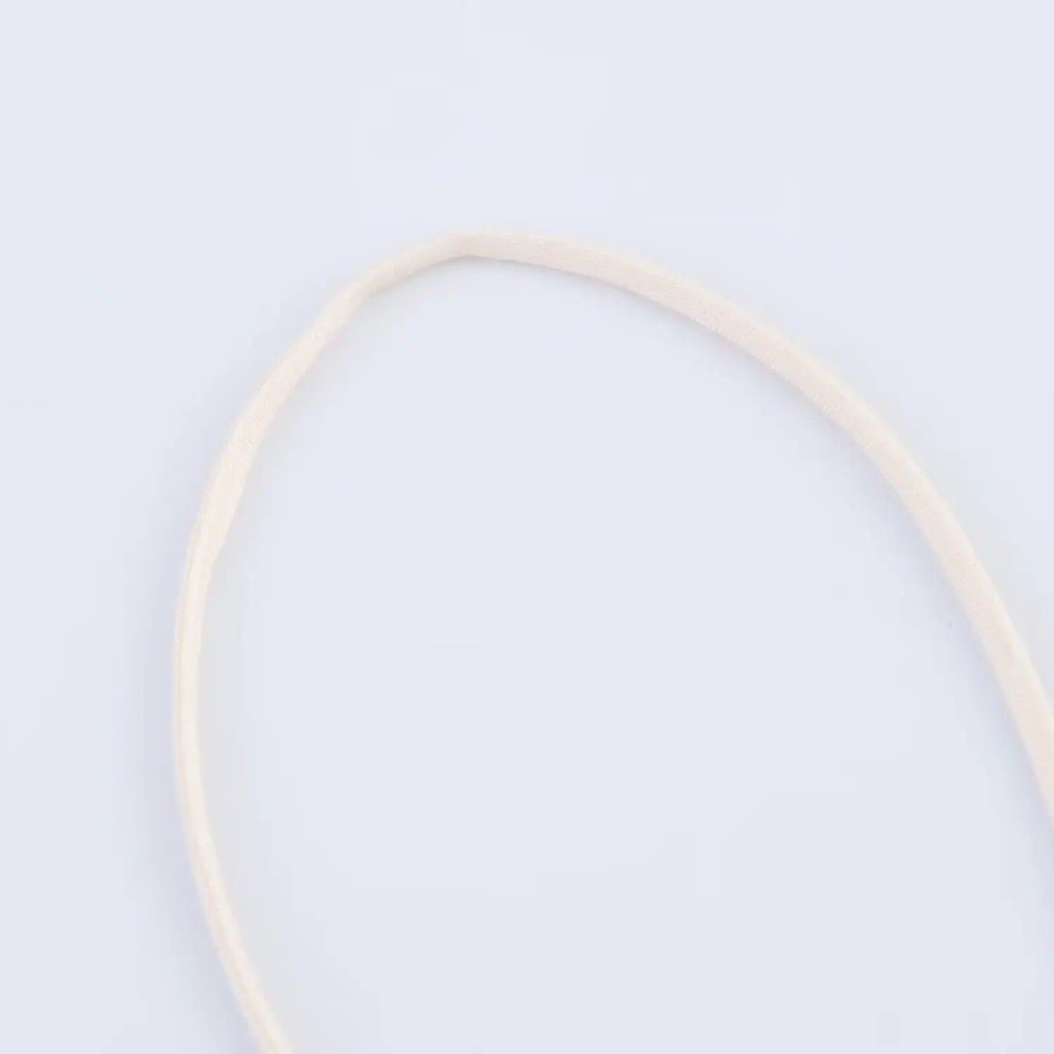 Close-up of the ultra-thin elastic spaghetti strap on the cream sequined slip dress