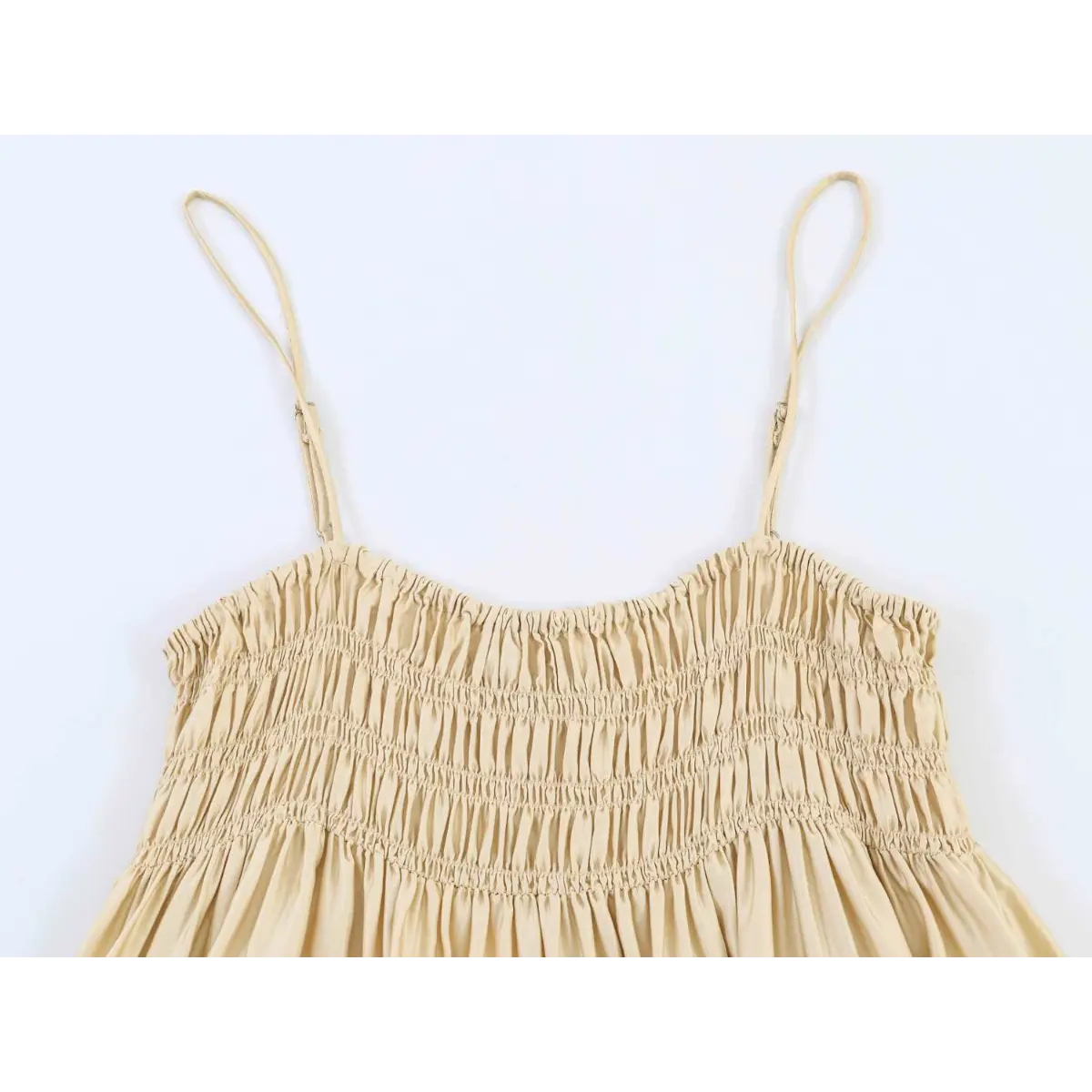 Close-up of the thin spaghetti straps and smocked bodice on the cream lace cami top
