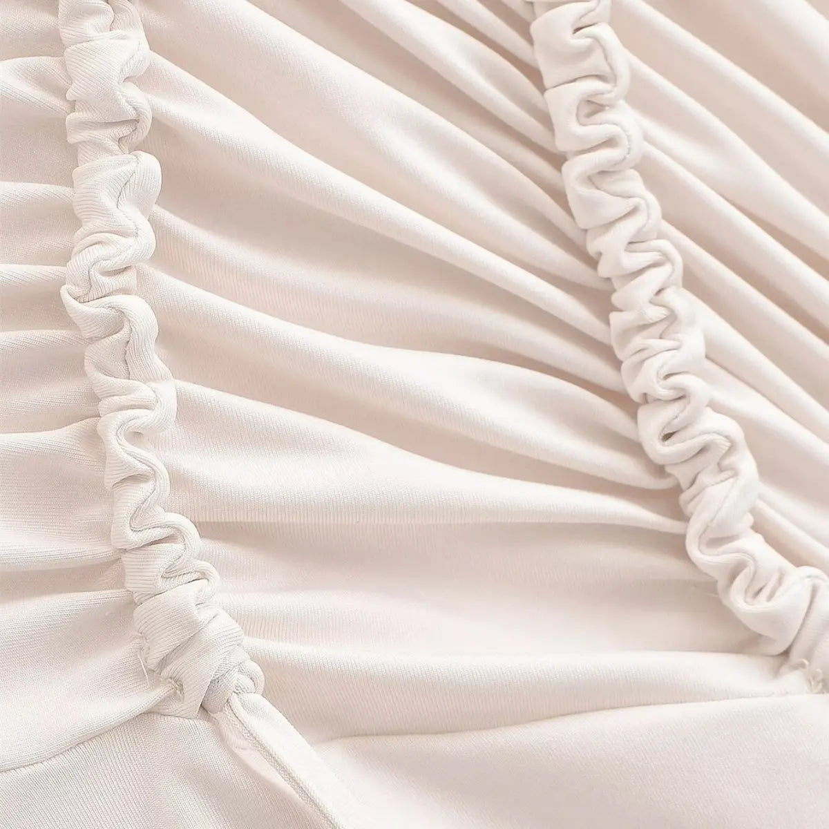 Close-up of the ruched drawstring details on the cream maxi dress, showing the fabric texture and gathered stitching