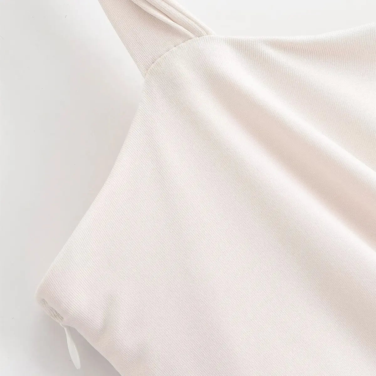 Close-up of the side zipper and strap construction on the cream maxi dress