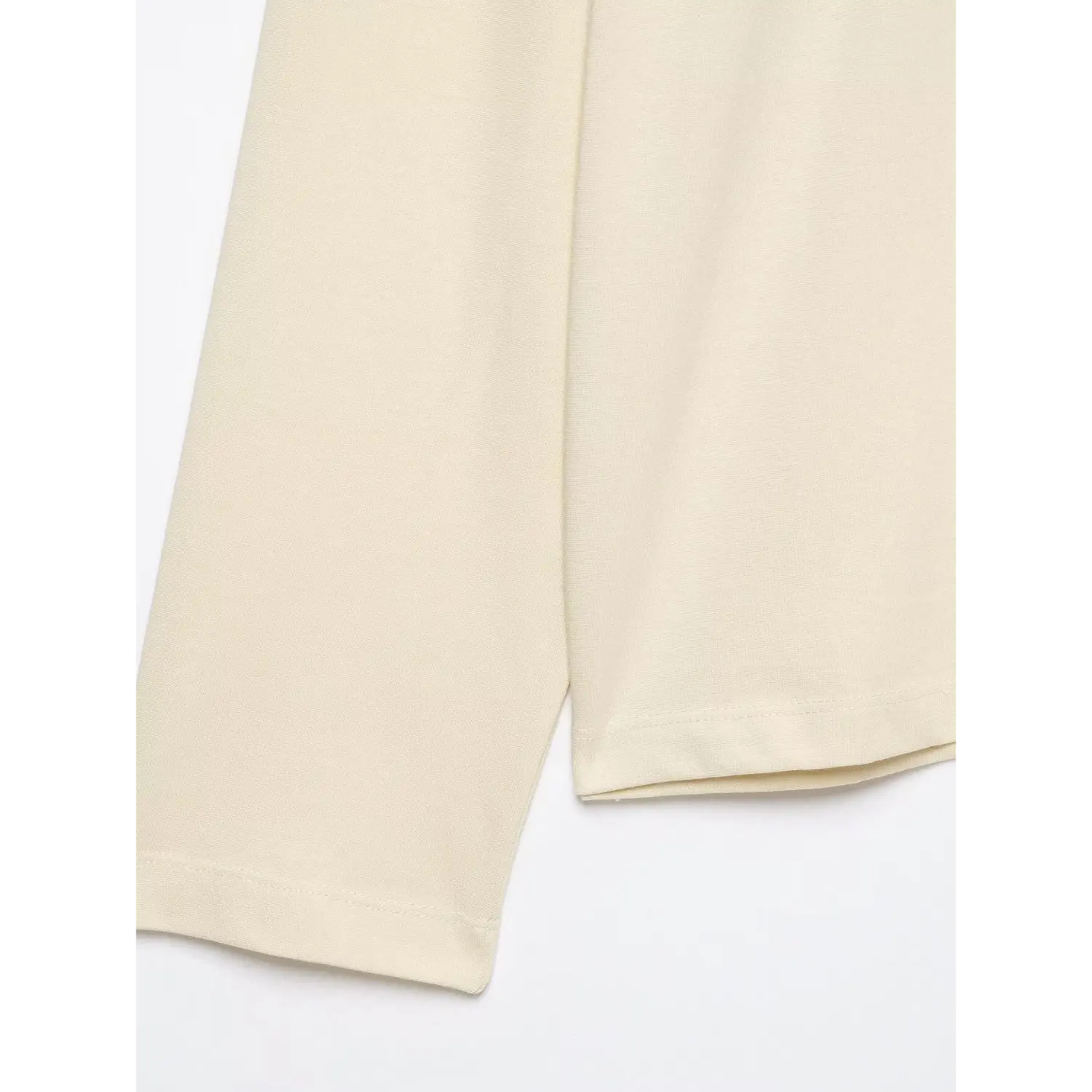 Close‑up sleeve hem and fabric texture of cream long sleeve striped polo shirt