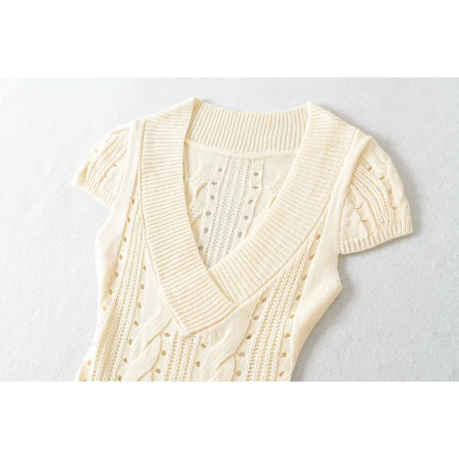 Close up of deep v neck ribbed trim hollow cable knit cream women short sleeve knit top chest detail
