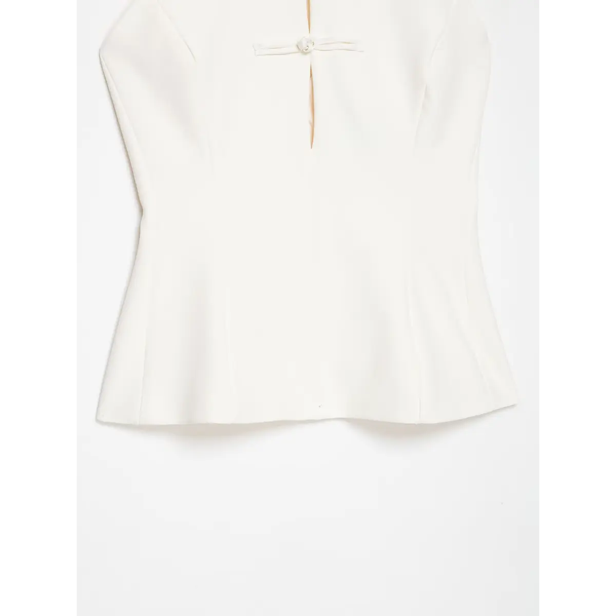 Front view of a cream-white halter top with traditional Chinese knot buttons and keyhole cutout.