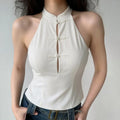 Full-body shot of a woman wearing a cream-white halter top with traditional Chinese knot buttons and a keyhole cutout, paired with jeans.