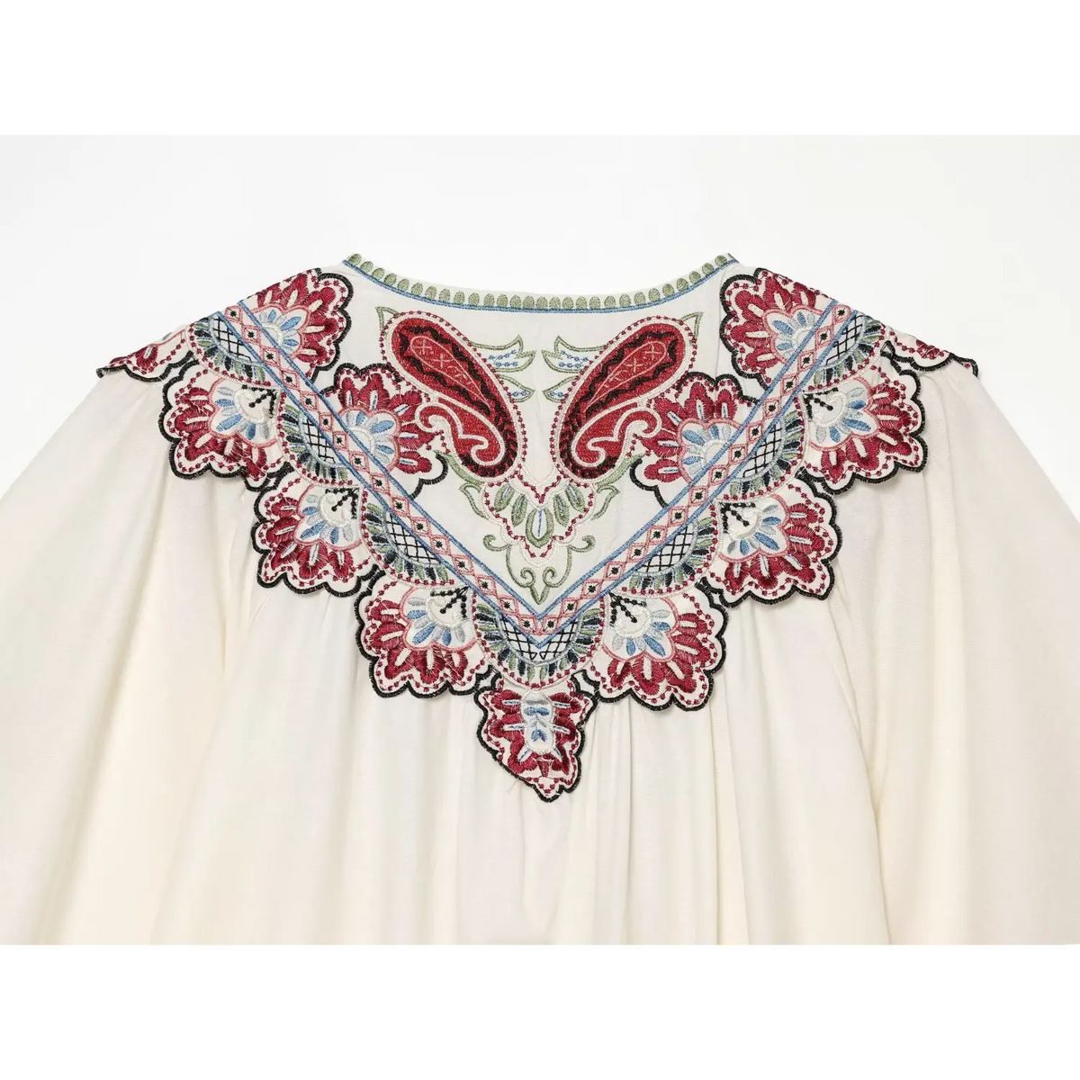 Close-up of back yoke paisley embroidery detail on cream white midi dress