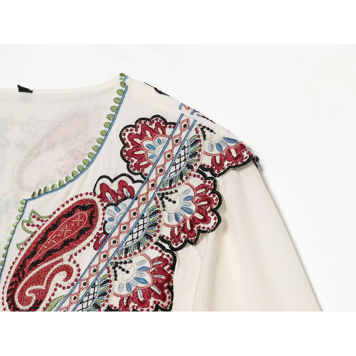 Close-up of shoulder and yoke embroidery on cream white paisley midi dress