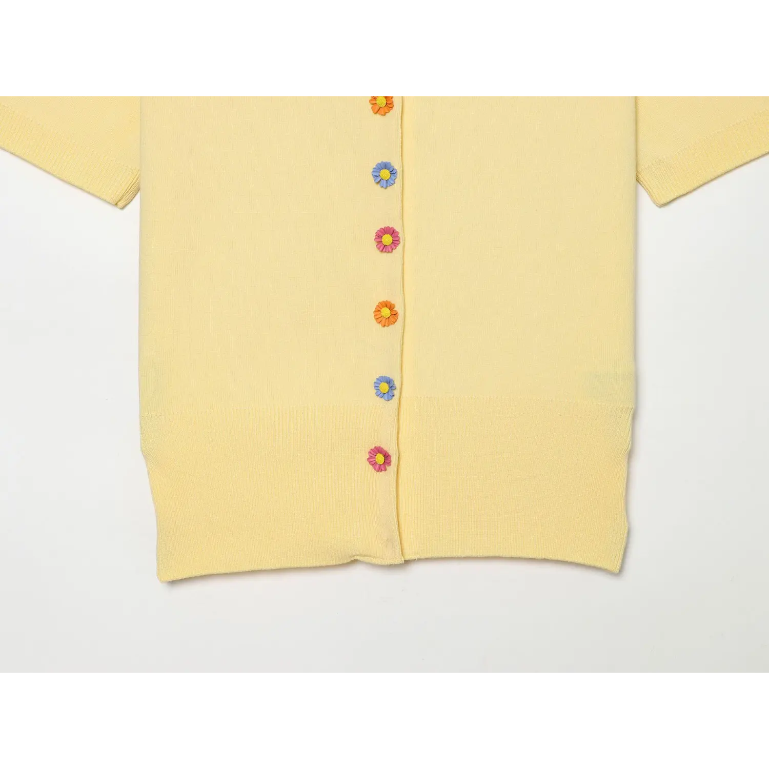 Lower front placket close-up, orange pink blue daisy flower buttons, ribbed waist hem, fine yellow knit fabric