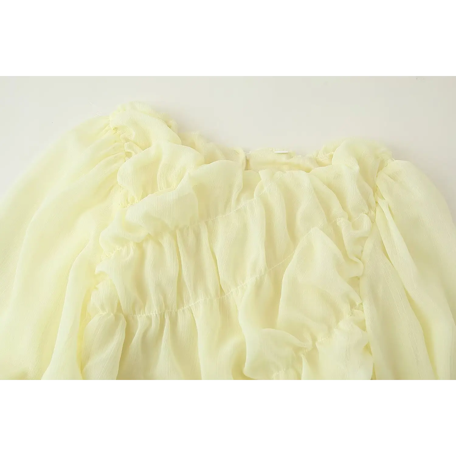 Full upper shot of soft pale yellow long sleeve maxi dress, multi-layer ruffle round neck, diagonal ruched front, bubble sleeve design, textured crinkle chiffon