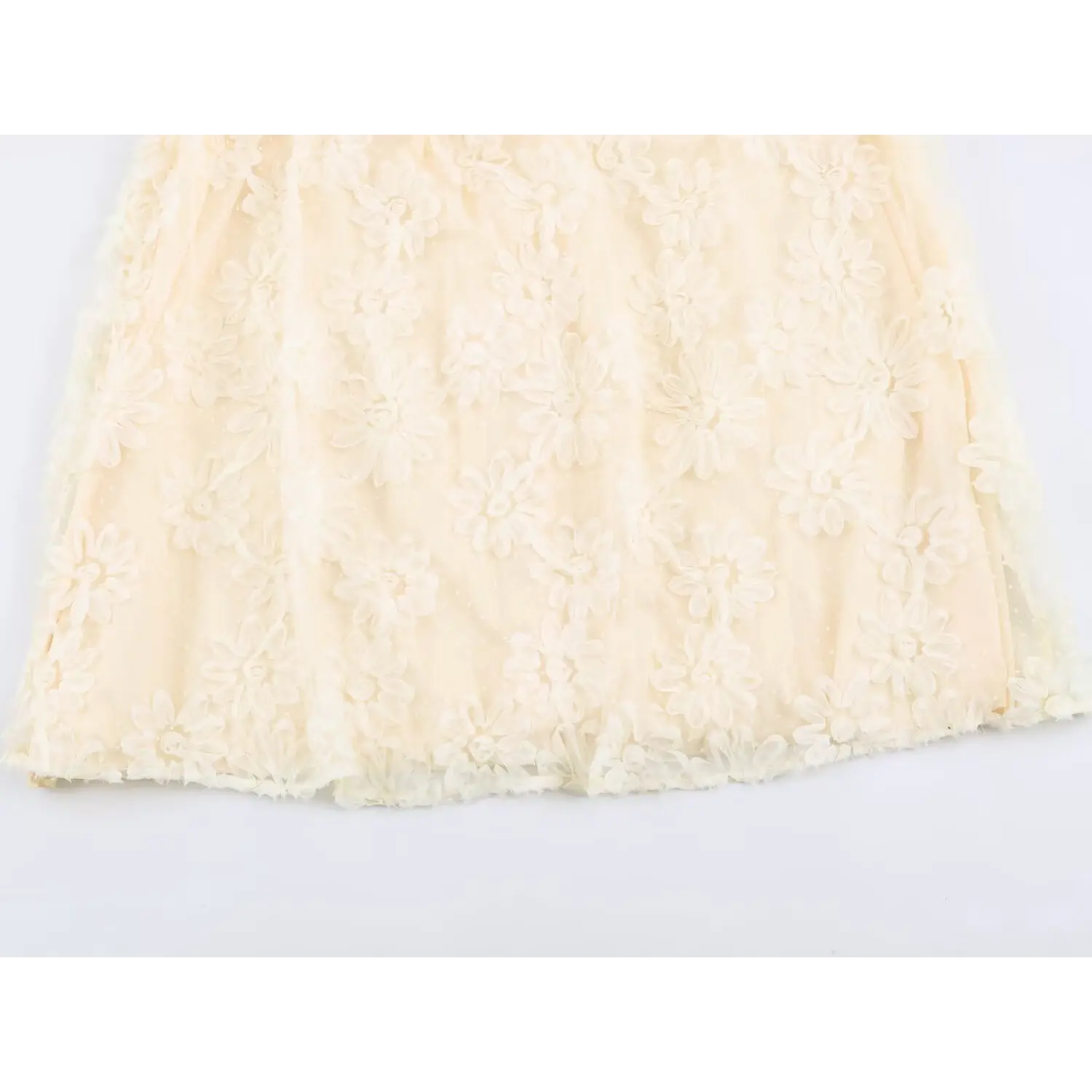 Close‑up of skirt fabric for cream maxi dress, 3d floral applique on polka dot tulle