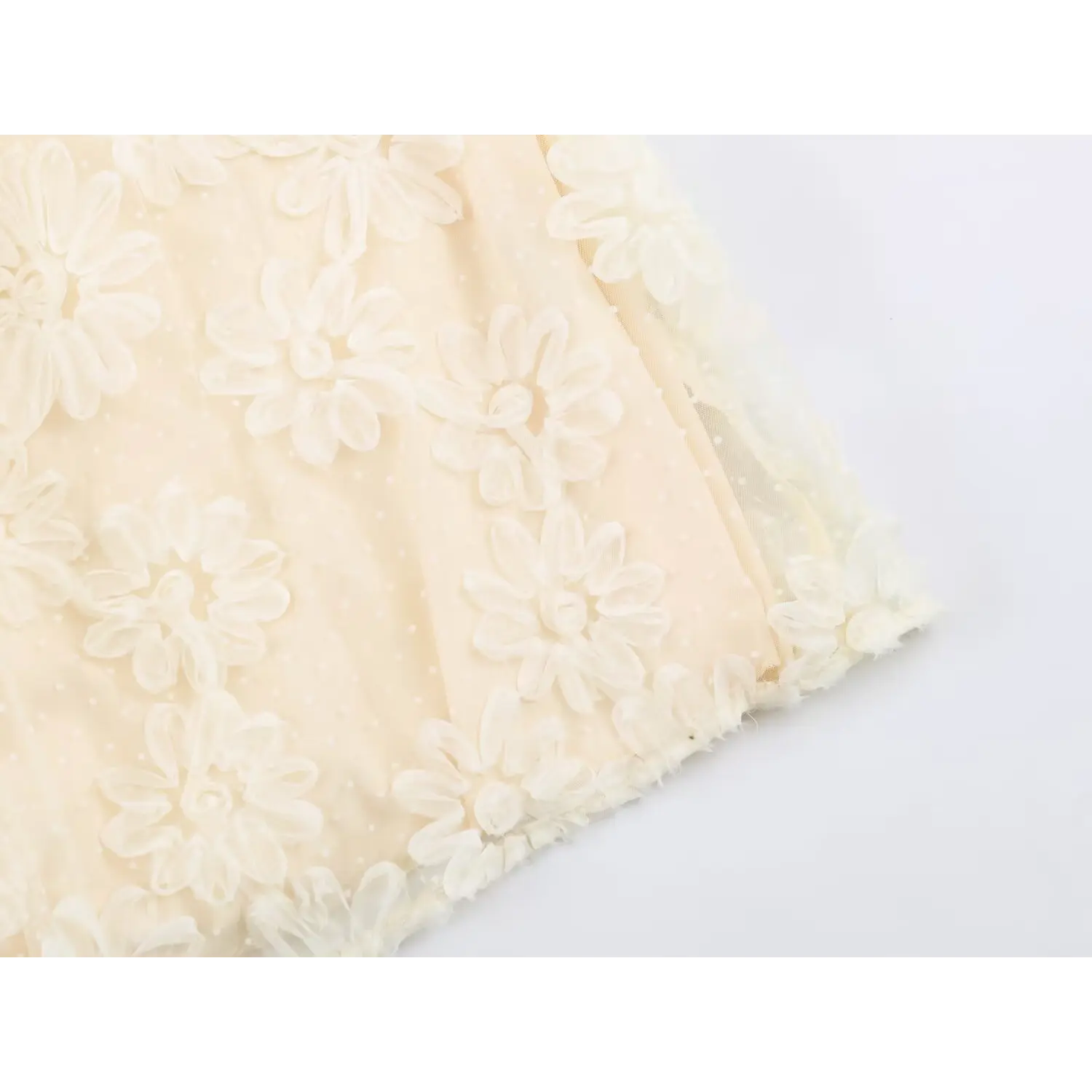 Close‑up of maxi dress skirt hem decorated with 3d fabric flower appliques