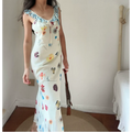 Model wearing cream colorful floral print maxi dress with blue ruffle neck detail