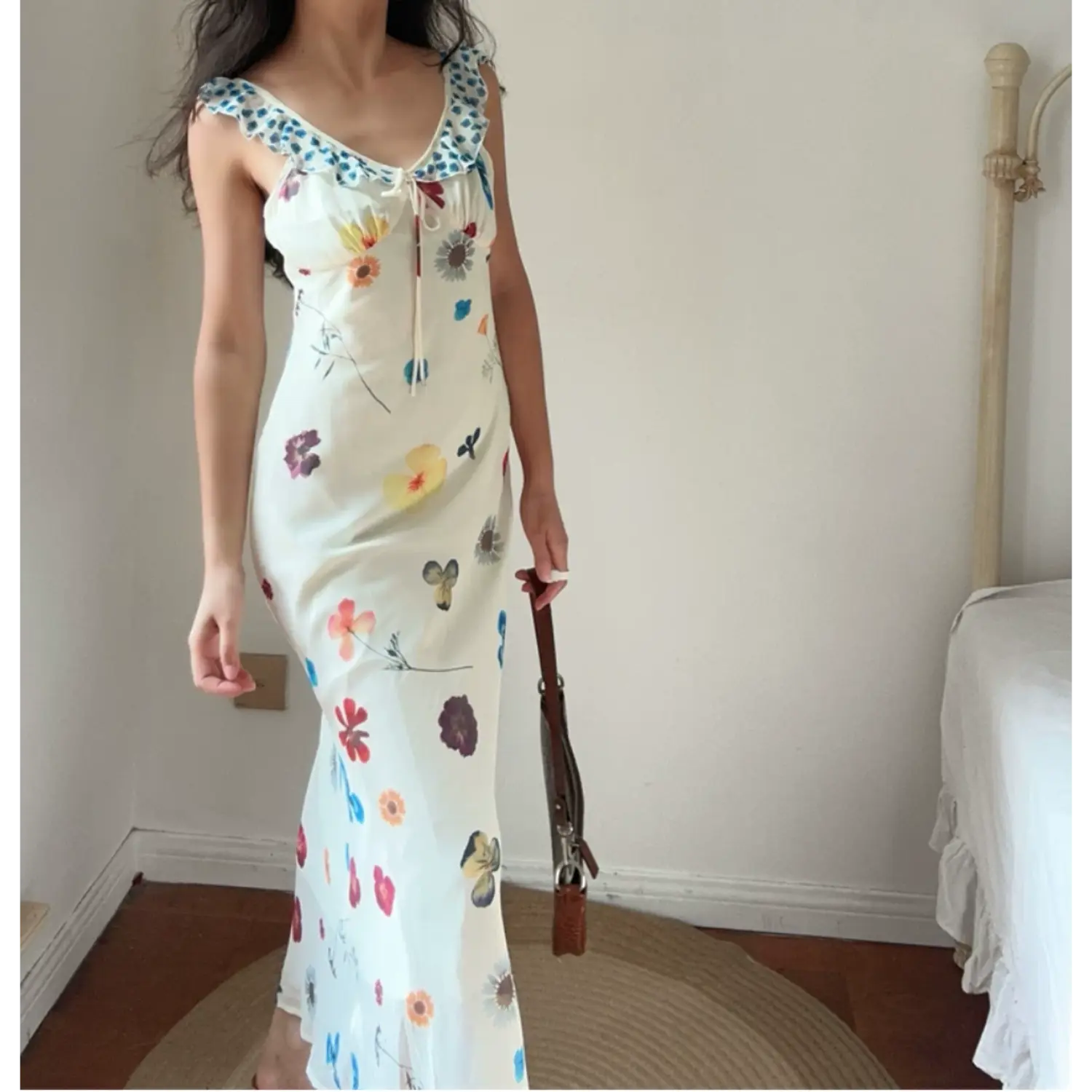 Model wearing cream colorful floral print maxi dress with blue ruffle neck detail