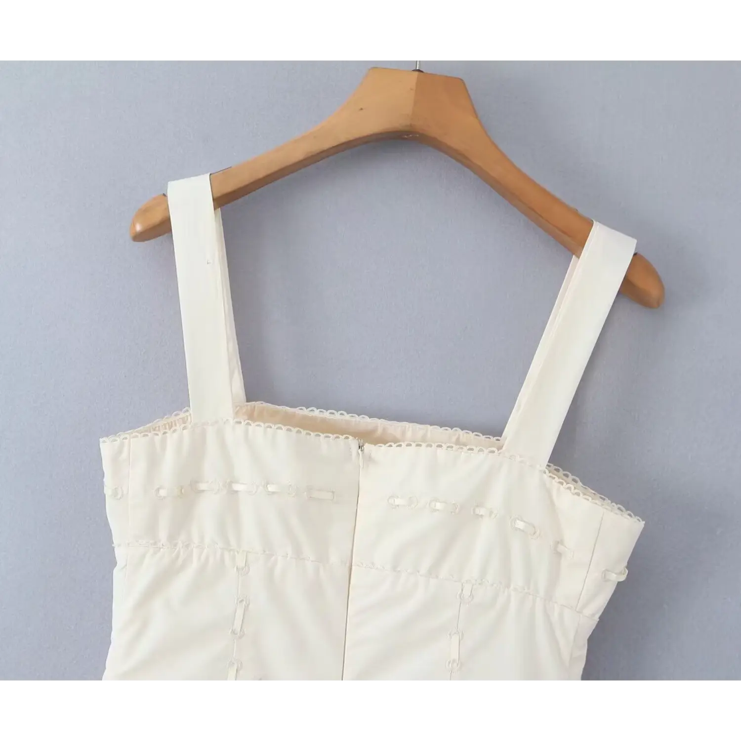Hanger shot focusing on back bodice scallop trim and hidden zipper