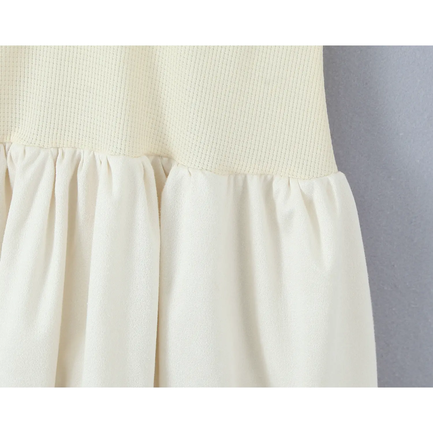 Close‑up of waist seam connecting waffle knit bodice and gathered bubble skirt