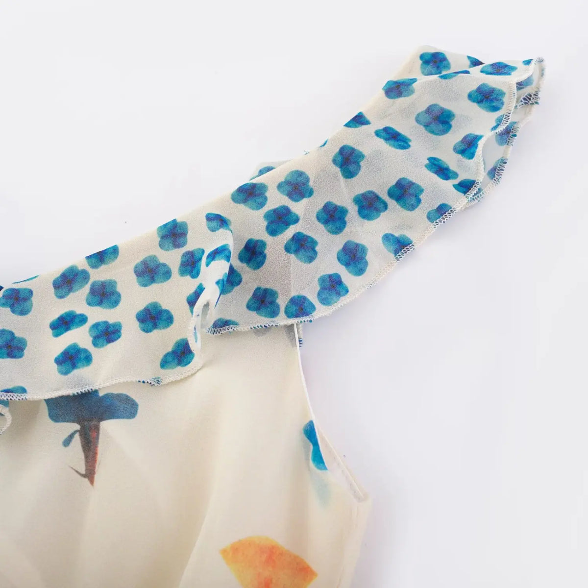 Close‑up of blue polka dot ruffle shoulder trim