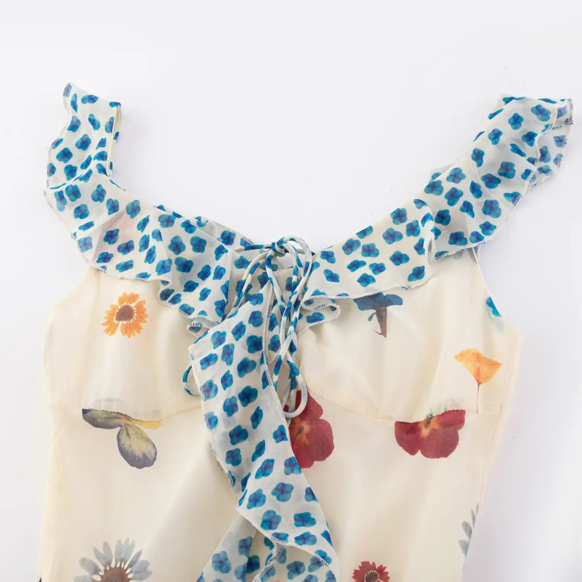 Close‑up of ruffle knot shoulder and v‑neck bodice
