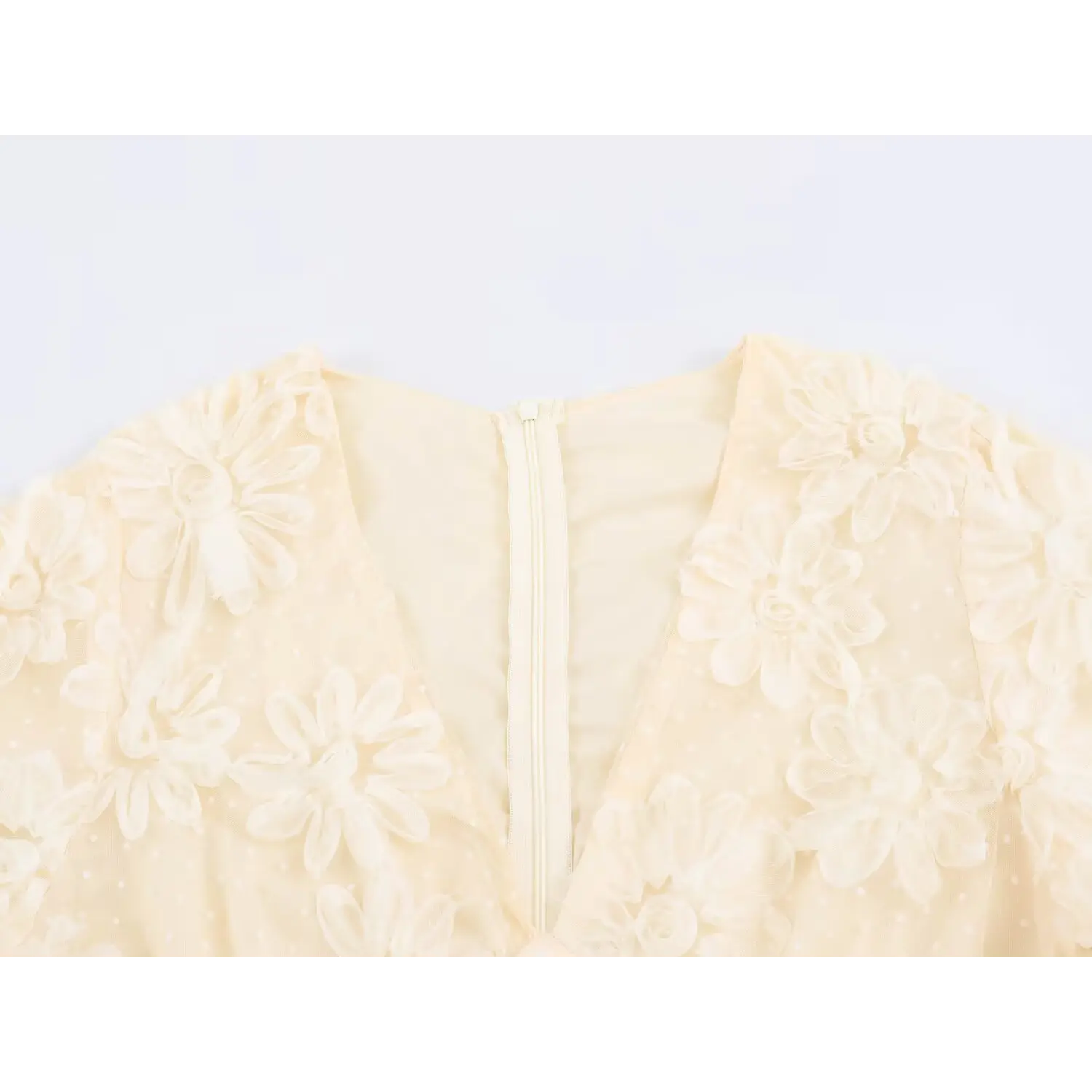 Close‑up of v‑neck and back zipper detail on cream 3d flower applique tulle maxi dress