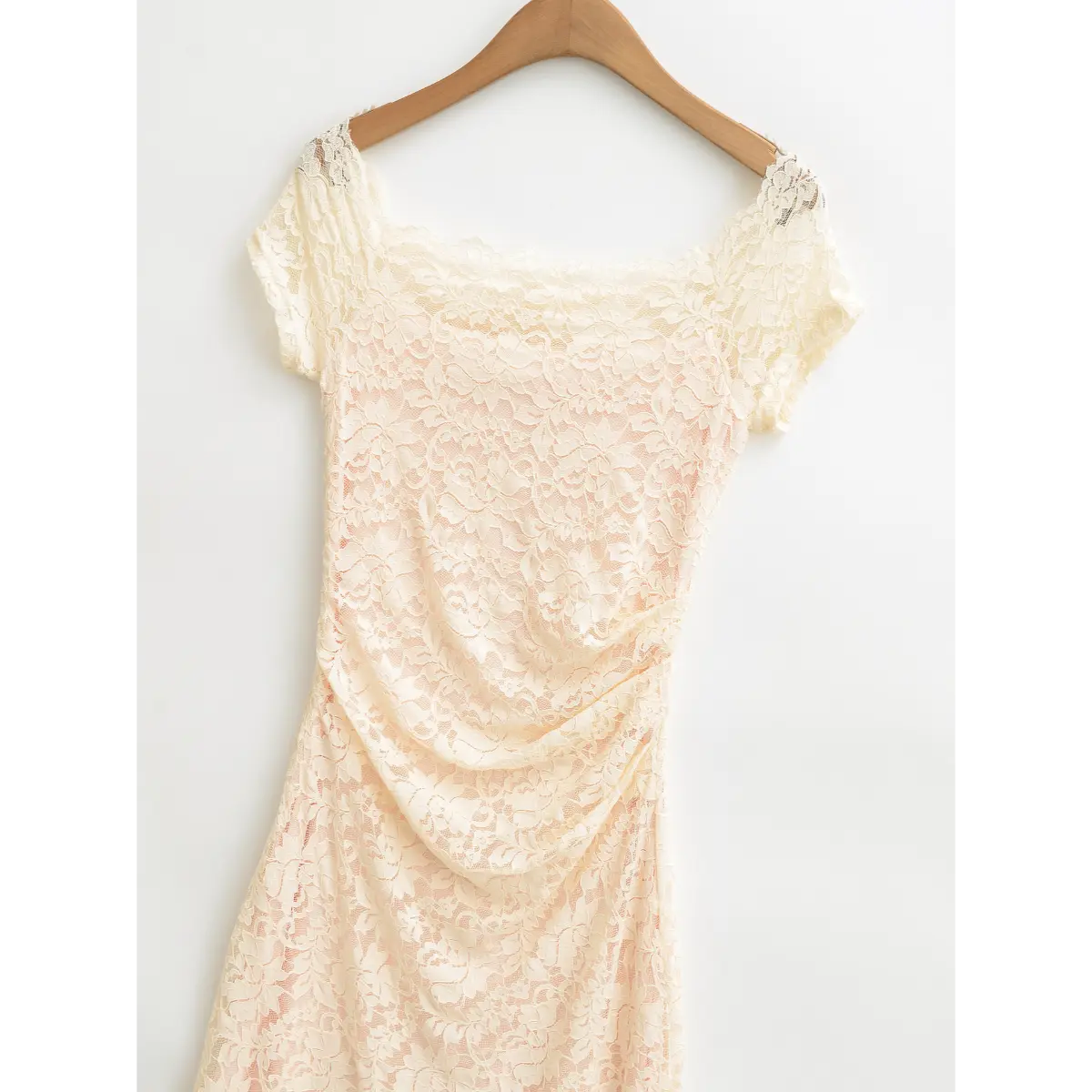 Close‑up of ruched bodice on cream lace maxi dress