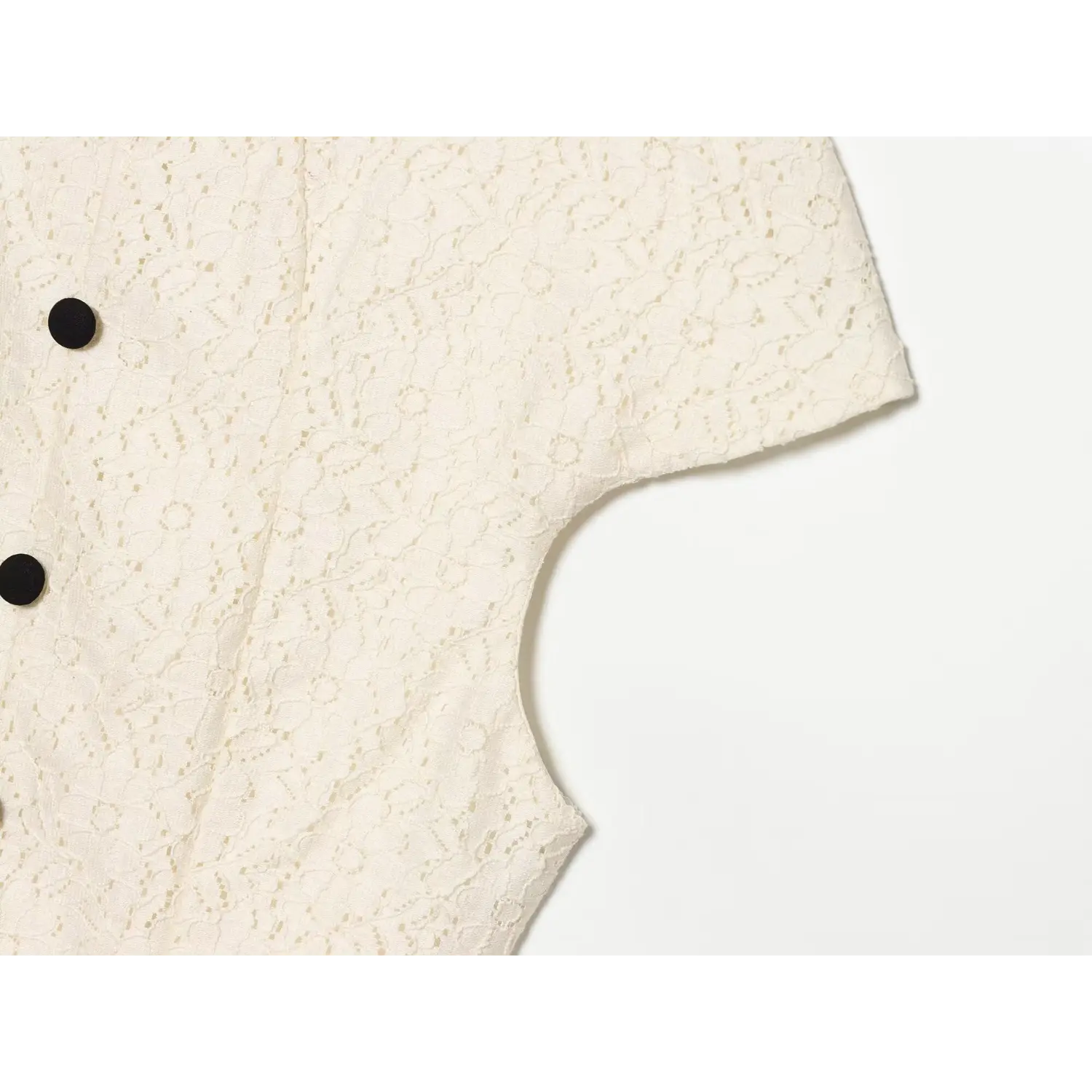 Close‑up of cream lace dress cap sleeve and armhole, delicate floral lace material and tailoring workmanship