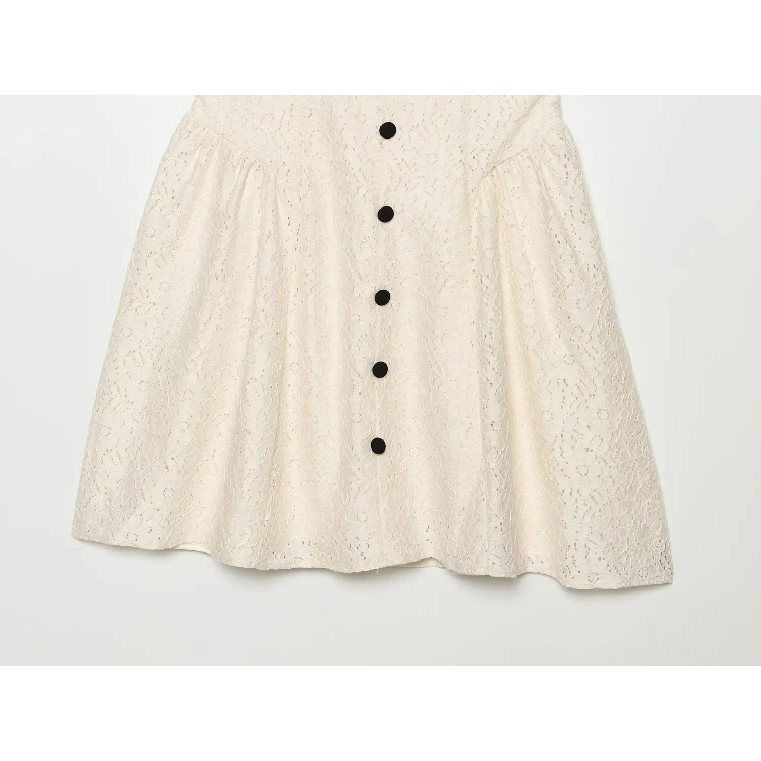 Flat lay partial view of cream lace fit‑and‑flare skirt, front black button placket, gathered flared hem