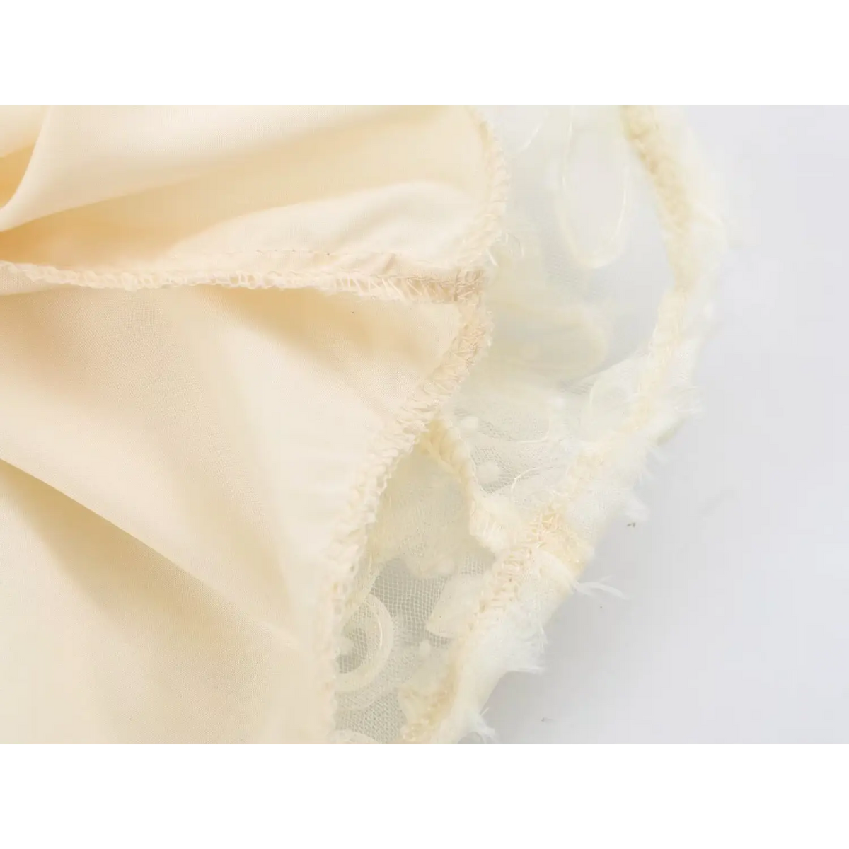 Close‑up of inner lining and stitching detail on cream 3d flower tulle maxi dress