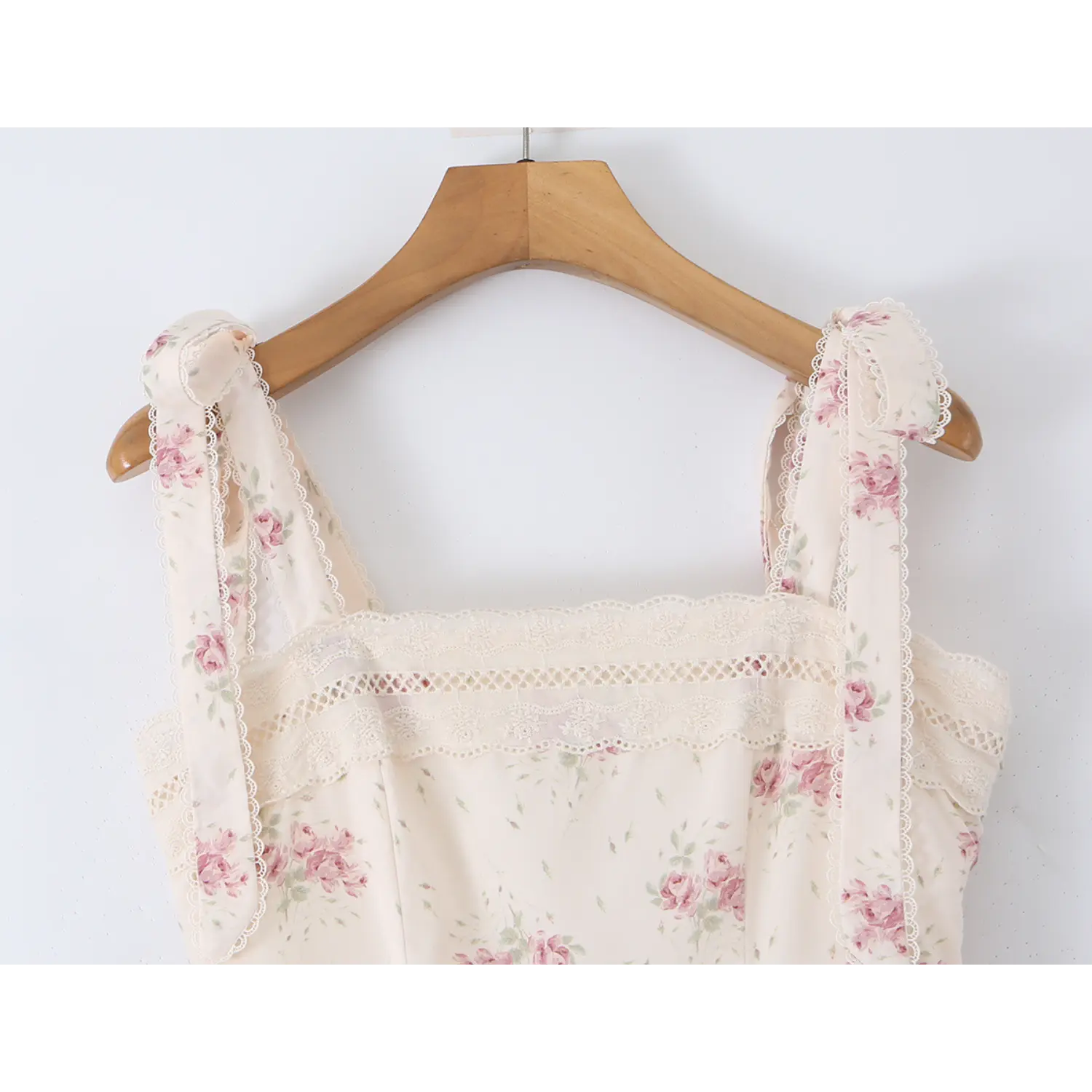 Close‑up of square neck bodice on cream pink floral maxi dress hanging on hanger