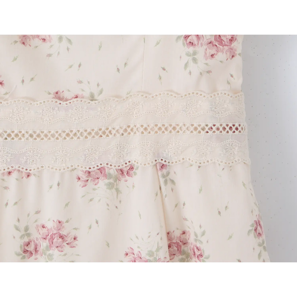 Close‑up of delicate lace trim at waist section of floral maxi dress
