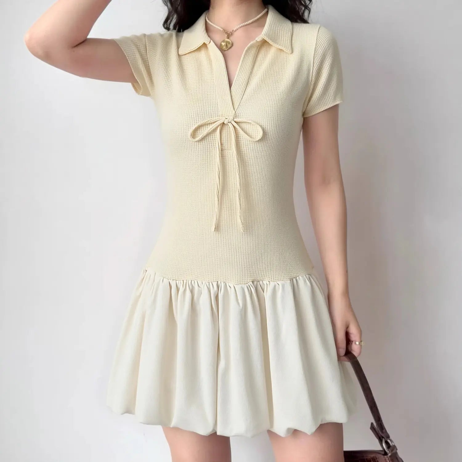 Woman wearing cream polo collar tie‑front bubble mini dress, casual fashion outfit