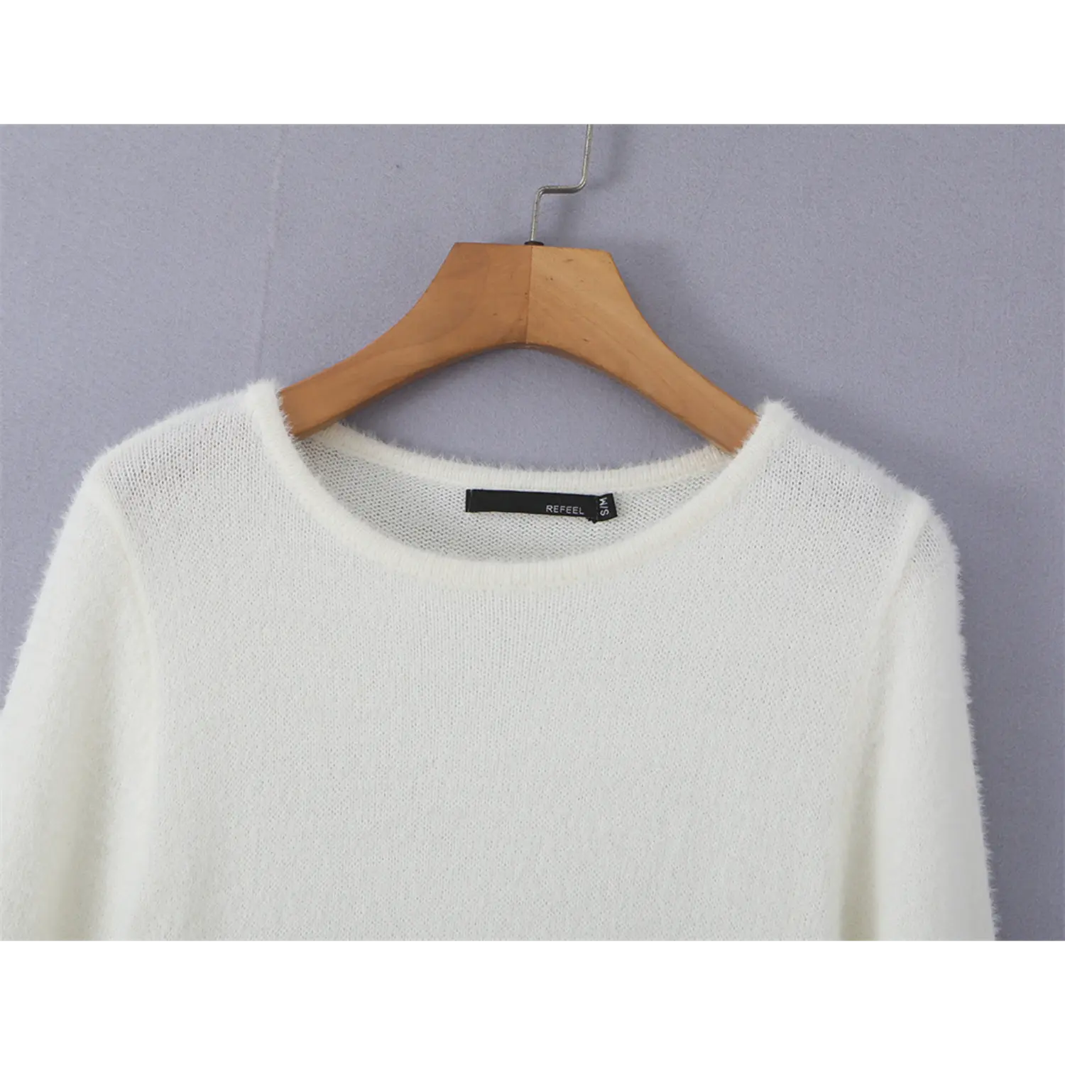 Close up crew neckline of soft fuzzy mink knit sweater top, inner fabric tag fine lightweight knit texture detail