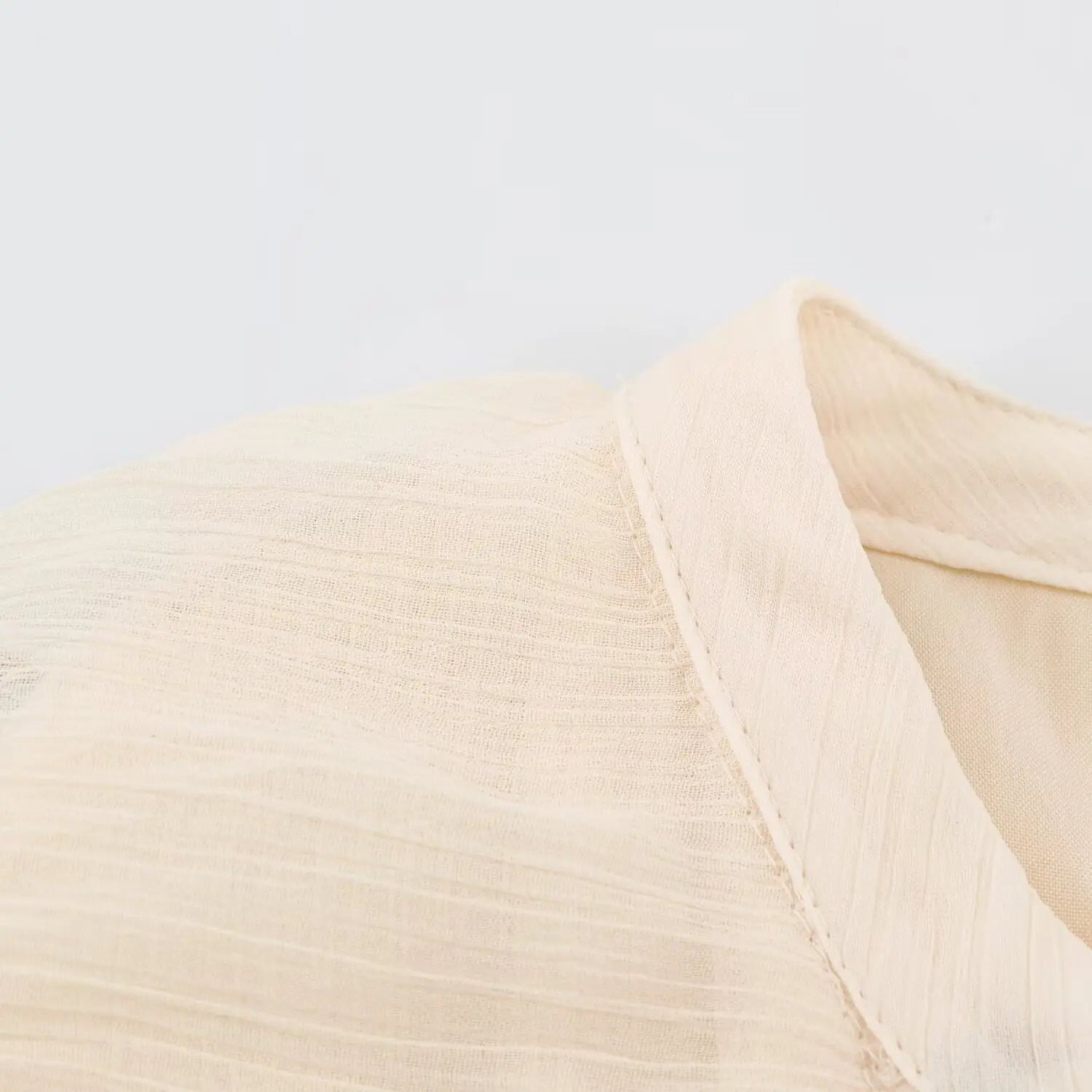 Extreme closeup crinkled lightweight fabric texture of beige sleeveless maxi dress