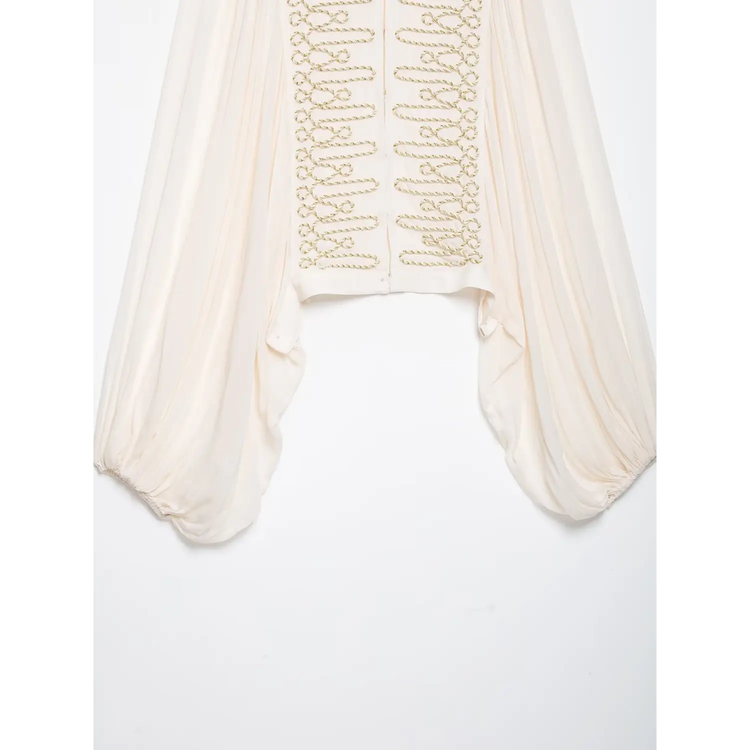 Flat lay detail of cropped hem, front gold embroidery and oversized bishop sleeves of white women blouse