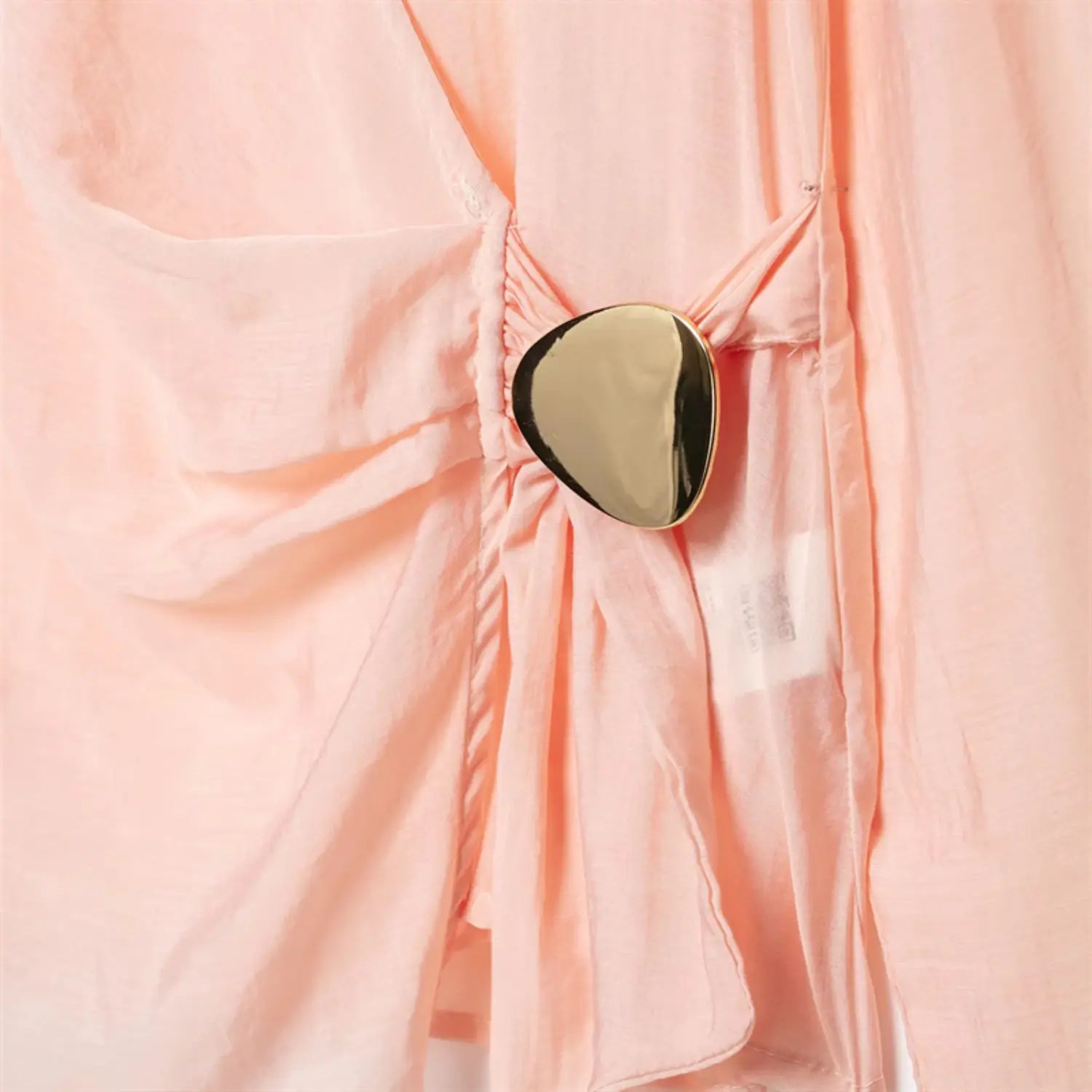 Upper torso full close-up, wrap cross V neck, side waist fabric ruching, irregular oval gold metal buckle ornament, glossy blush satin