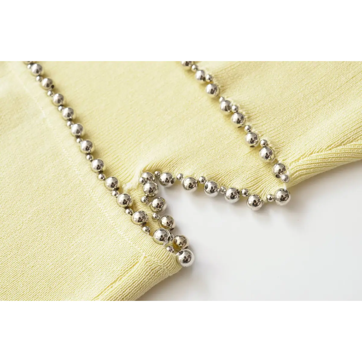 Curved hollow cut edged with round silver beads knit fabric detail