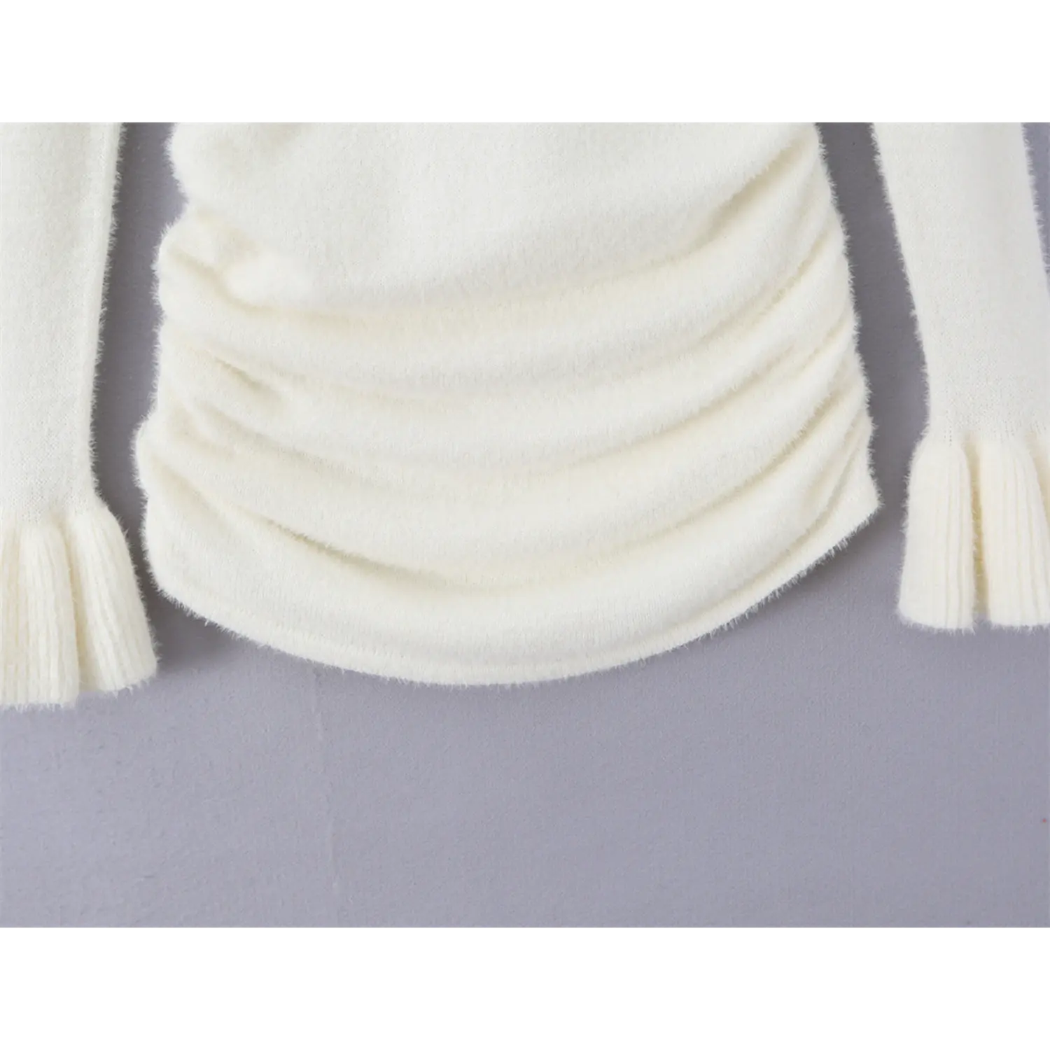 Bottom hem close up curved asymmetrical hem with layered waist ruched fuzzy plush knit long sleeve fitted top