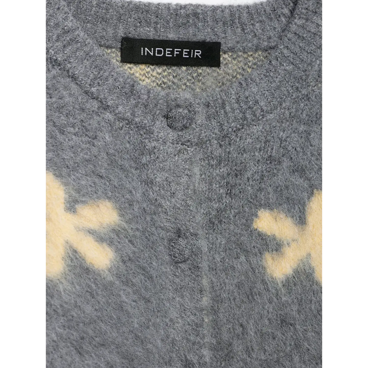 Close-up of neck label and same-tone knit buttons