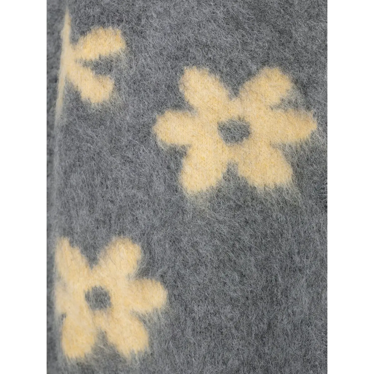 Close-up of cream daisy intarsia knit detail on fuzzy yarn