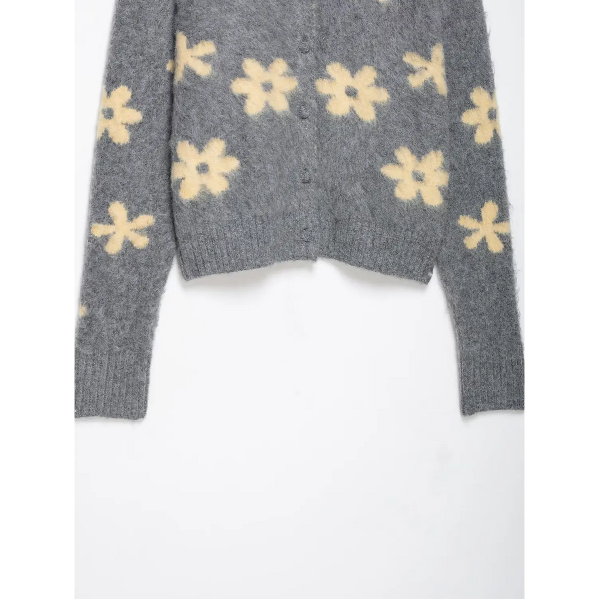 Close-up of ribbed hem and long sleeves with daisy pattern