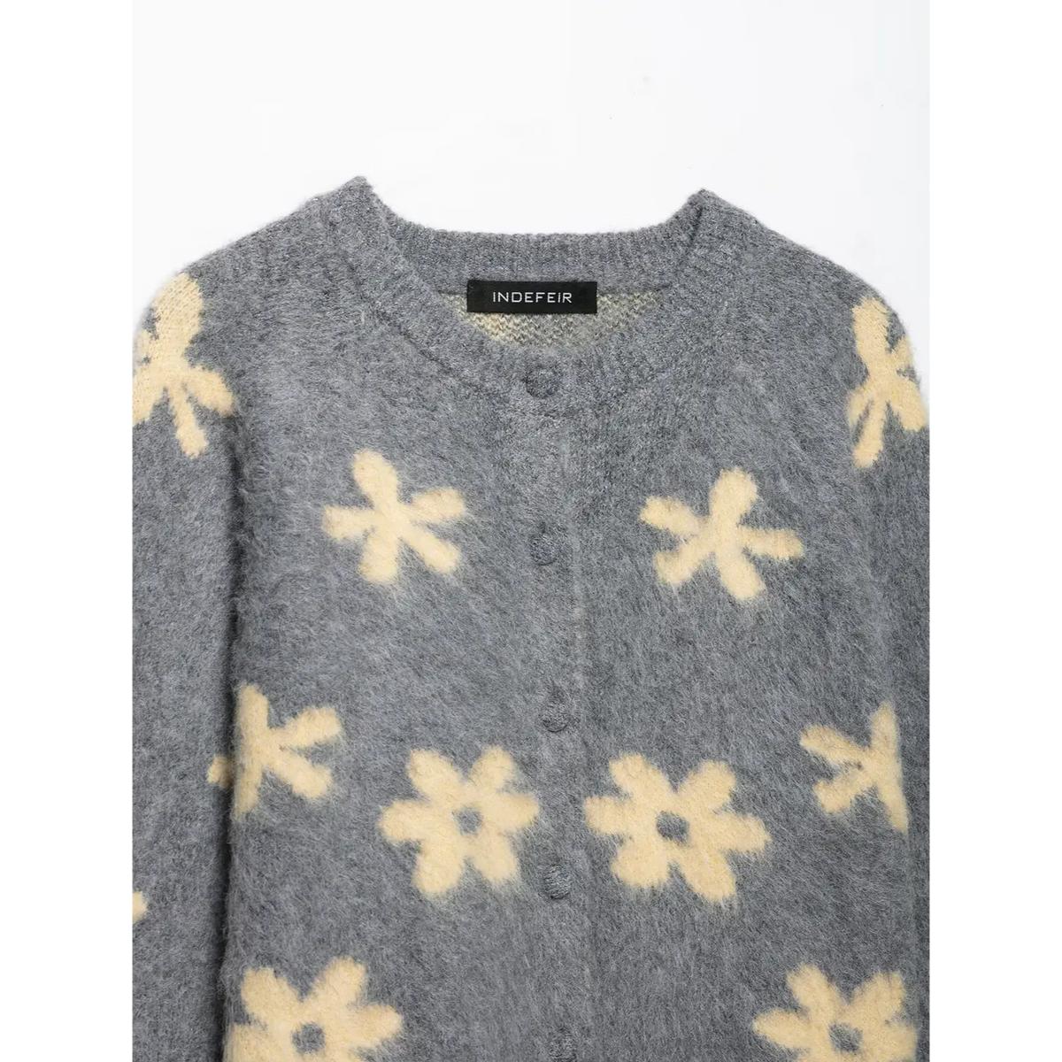 Close-up of round neckline, button placket and brand label