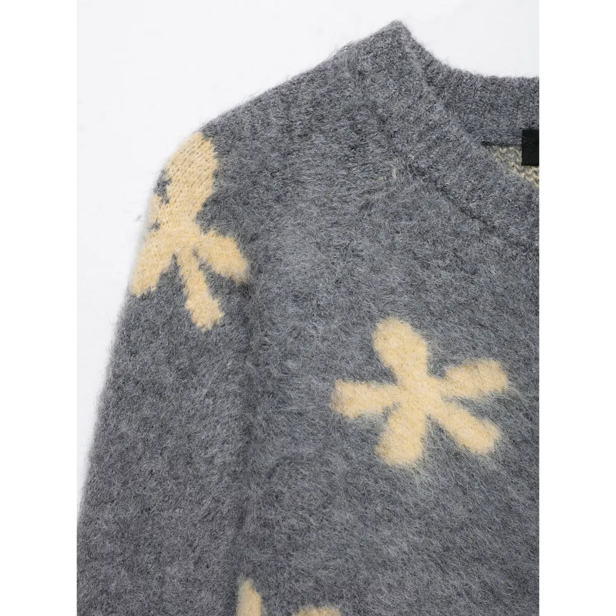 Close-up of shoulder flower intarsia and fuzzy brushed knit texture