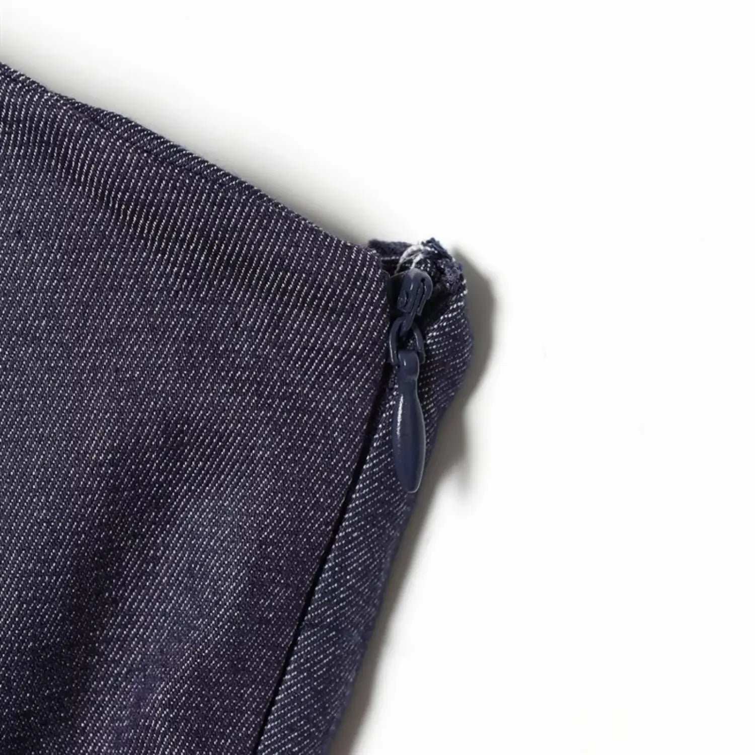 Side waist invisible zipper close-up, matching dark blue coated zipper teeth & pull tab, neat fabric seam binding