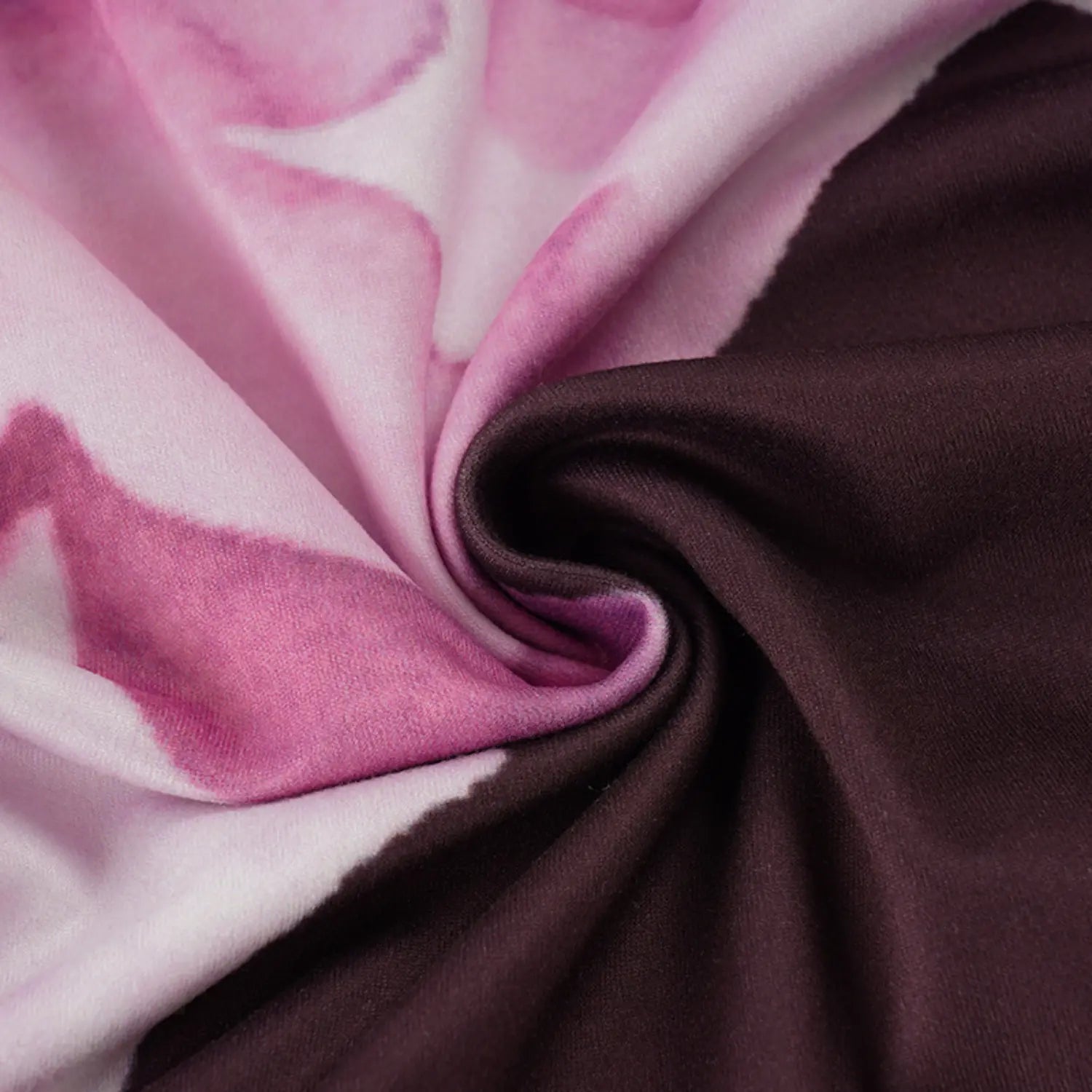 Close folded texture shot of lightweight stretch knit fabric, solid dark brown base blended with soft gradient pink purple watercolor magnolia floral print, smooth drapeable material